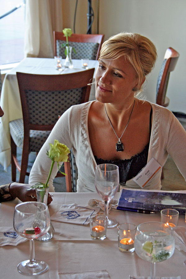 Conference speaker at a United Nations reception dinner. A conference program sits on the table in front of her.