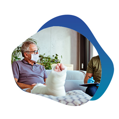 Middle-aged male in a foot cast talking to an in-home healthcare worker